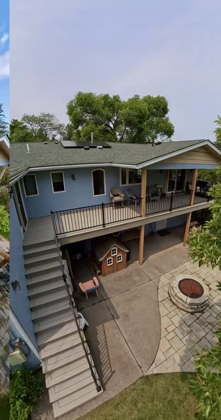 Aerial view of the rebuilt two-story composite deck with black aluminum railing and wide stair